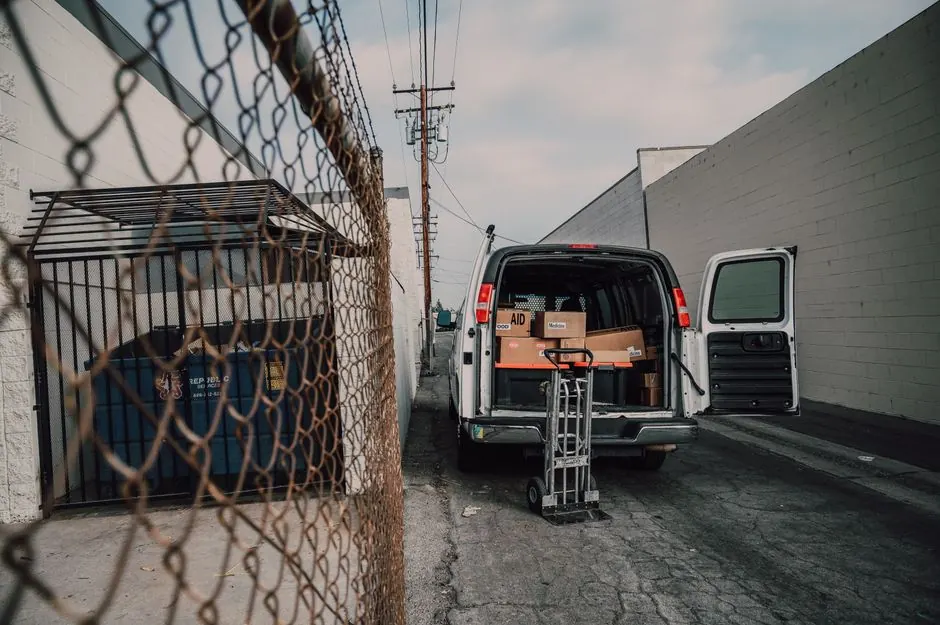 An open van loaded with boxes in an alley, ready for donation deliveries.